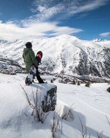 Snowboarder blickt auf die Aussicht auf Valmeinier